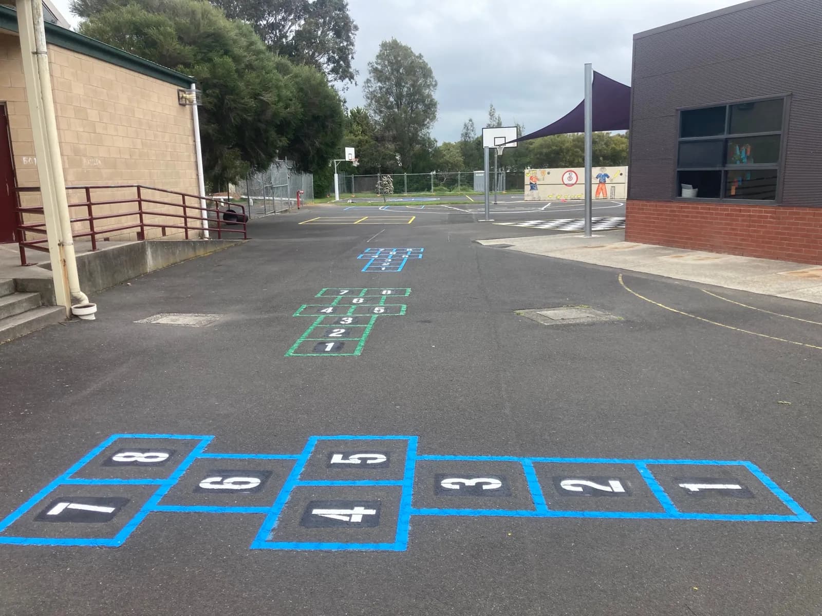 School playground with brightly painted hopscotch and game markings on asphalt