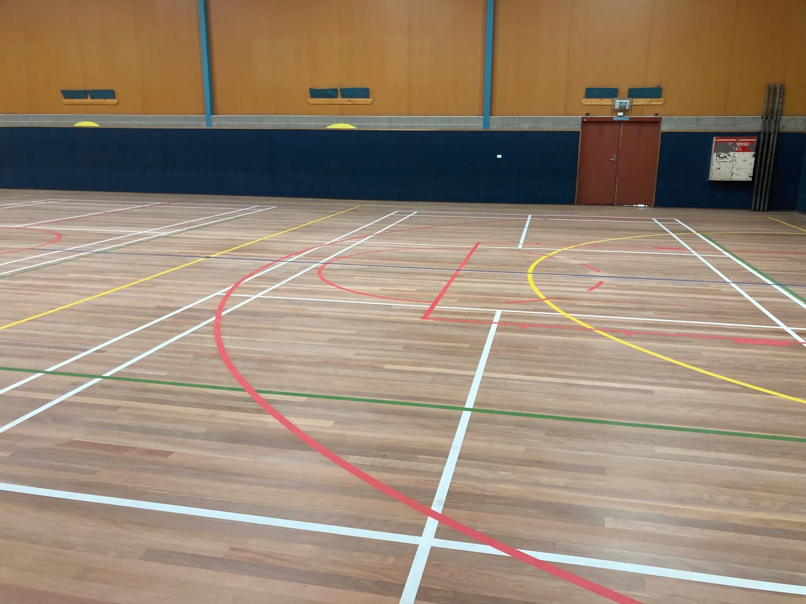 Indoor Basketball Courts for Gyms Indoor timber sports hall floor marked with coloured lines for several sports